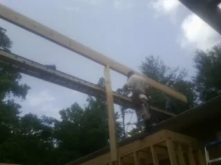 Carpenter setting a ridge beam over a new addition frame — Ice Dam Removal by Roofing Brothers in Lester