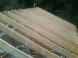 New roof rafters set over an addition before sheathing in Lester