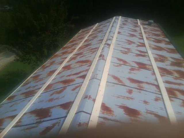 Rusted metal roof panels with new wood purlins before replacement — Storm Damage Roof Repair in Lester by Roofing Brothers